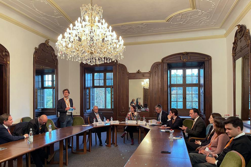 Prof. Dr. Daniel Göler (stehend) bei der Begrüßung der Podiumsgäste am runden Tisch im Senatssaal im Nikolakloster der Universität Passau.