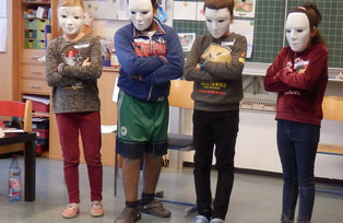 Vier Kinder mit weißen Masken vor dem Gesicht